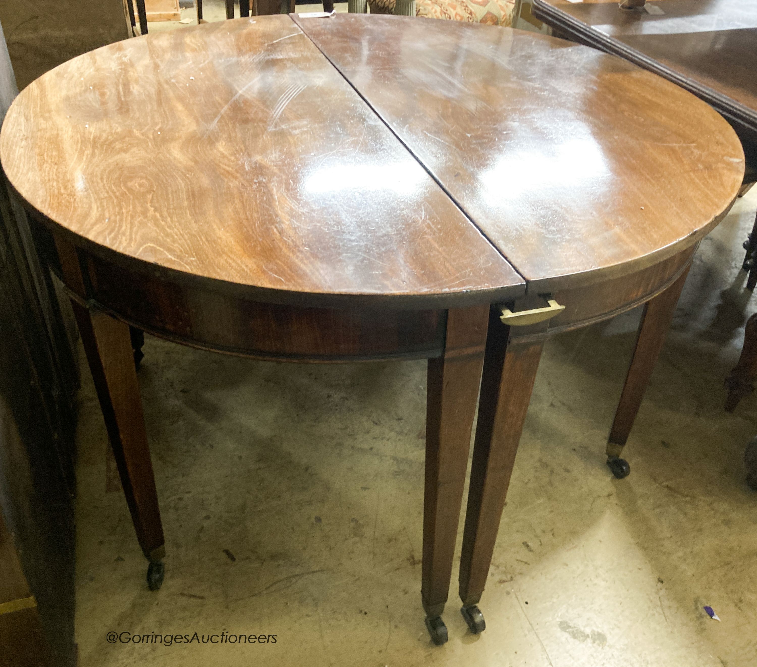 A pair of George III mahogany D shaped table sections, each measures length 120cm, depth 56cm, height 70cm